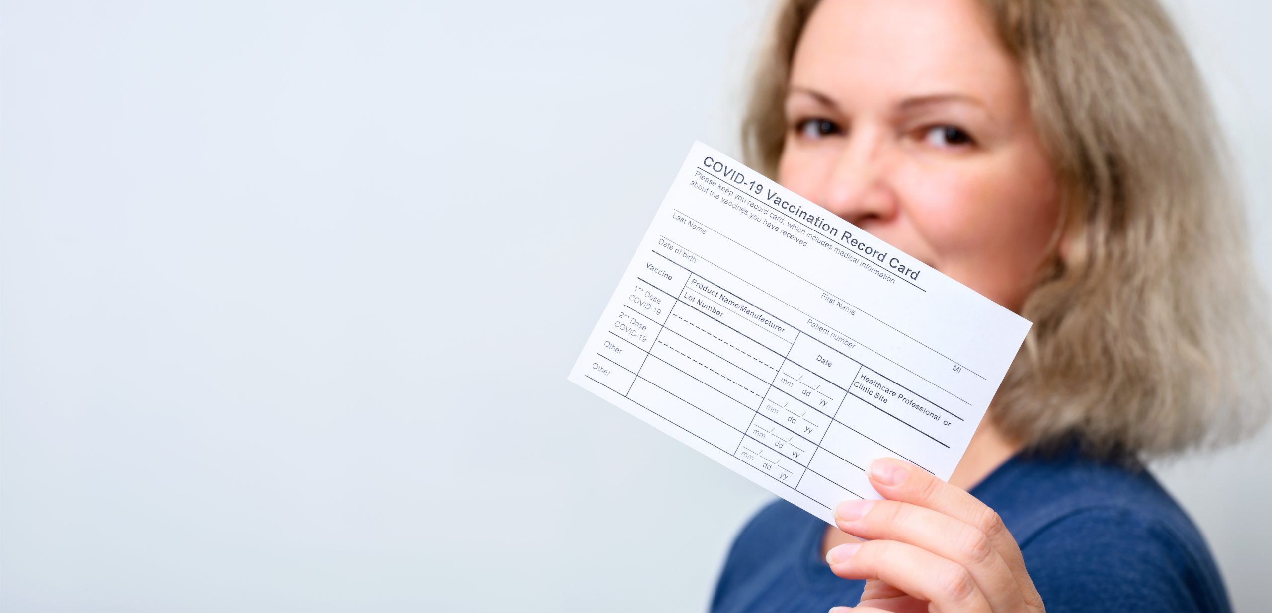 woman holding vaccination card